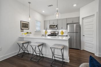 A modern kitchen with stainless-steel appliances and wood floors at Turnberry Park Luxury Rental Homes in Gardendale, AL